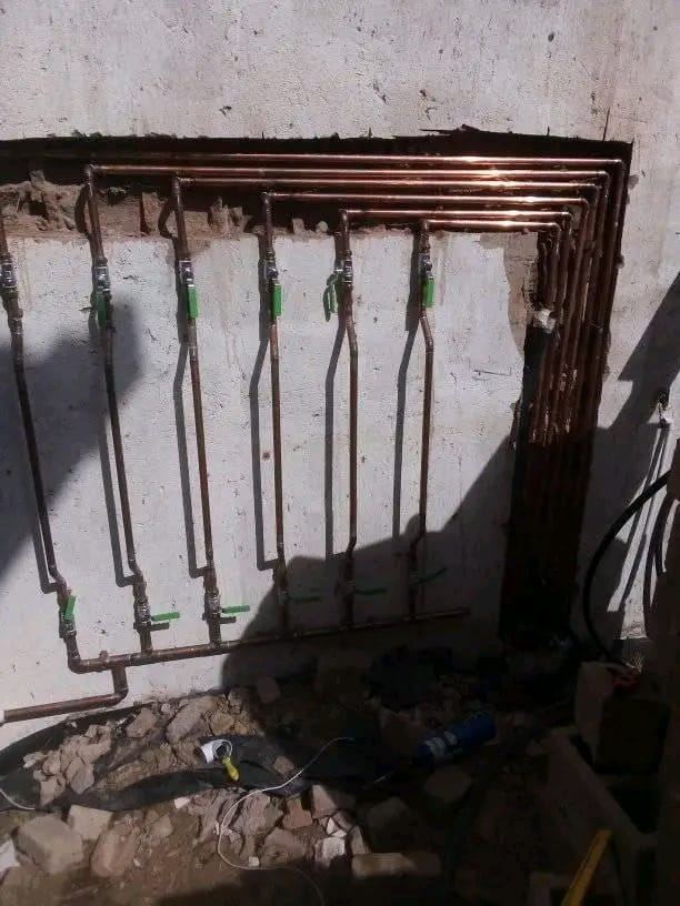 Copper pipes with isolating valves fixed to a wall